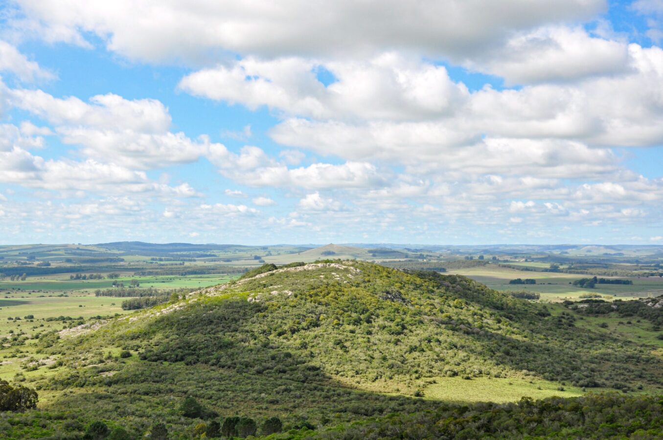 A green hill overlooking a plain, under a blue sky filled with clouds, Lavalleja-Department-Uruguay